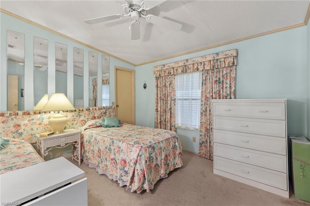 48 Oceans Boulevard, Unit 48 Naples, FL 34104 - Photo 18 of 26 a bedroom with a bed and a chandelier