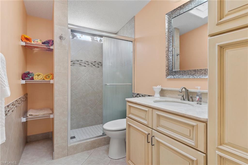 48 Oceans Boulevard, Unit 48 Naples, FL 34104 - Photo 20 of 26 a bathroom with a granite countertop sink toilet and shower