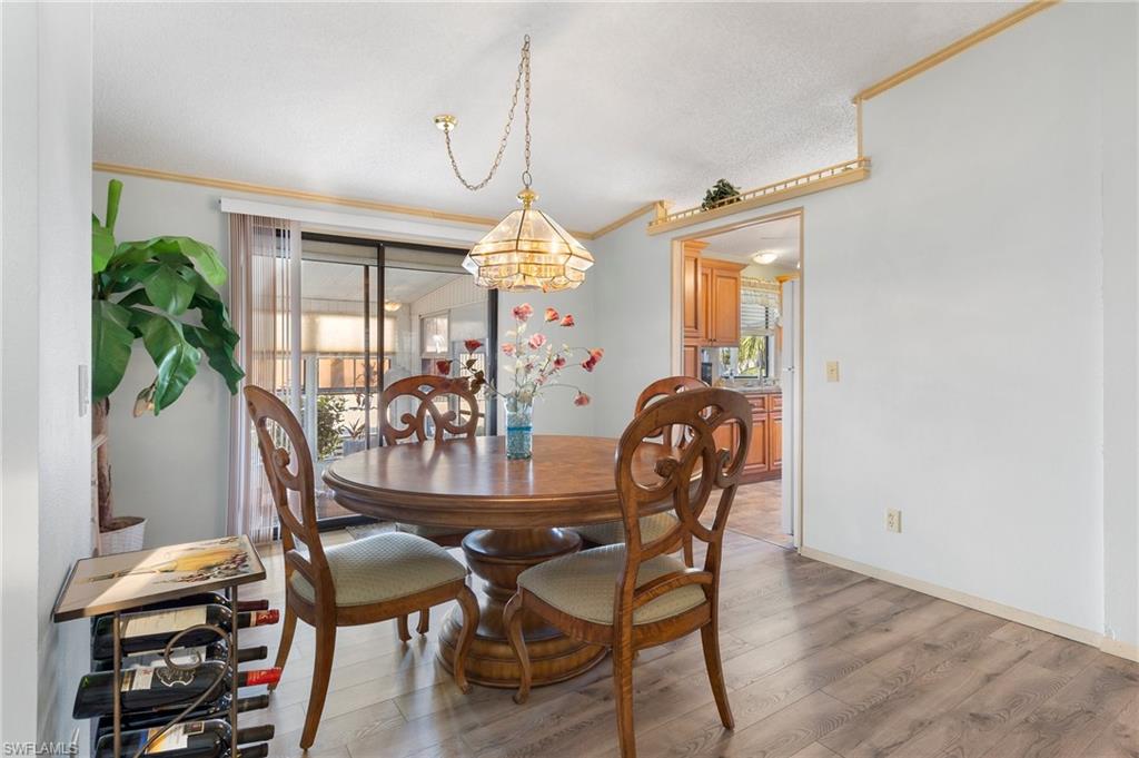 48 Oceans Boulevard, Unit 48 Naples, FL 34104 - Photo 8 of 26 a view of a dining room with furniture and chandelier