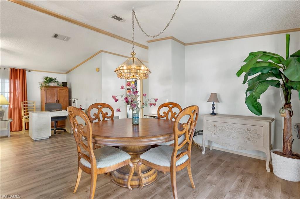 48 Oceans Boulevard, Unit 48 Naples, FL 34104 - Photo 10 of 26 a dining room with furniture potted plants and wooden floor