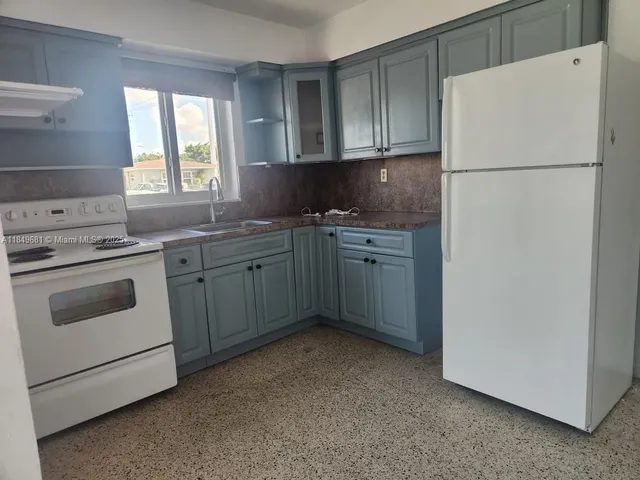 a kitchen with a white cabinets and white appliances