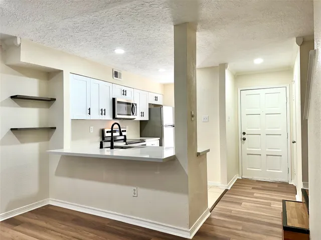 a view of kitchen with wooden floor and electronic appliances