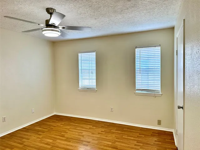 a view of a room with wooden floor and fan