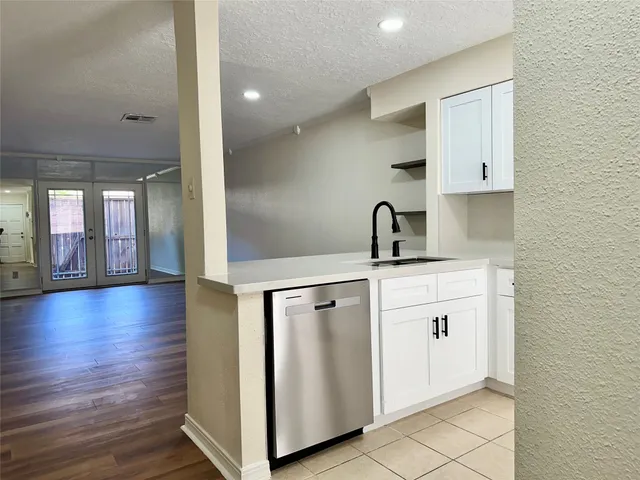 a kitchen with a sink and a large mirror