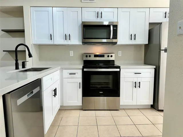 a kitchen with cabinets a sink and stainless steel appliances