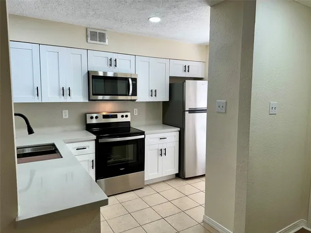 a kitchen with white cabinets and stainless steel appliances