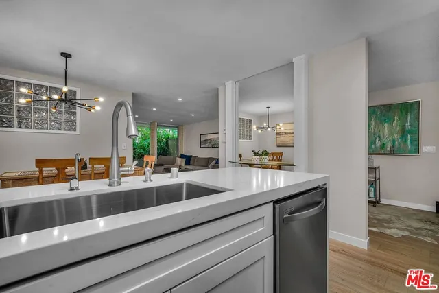 a dining hall with granite countertop a sink and dishwasher a stove with wooden floor