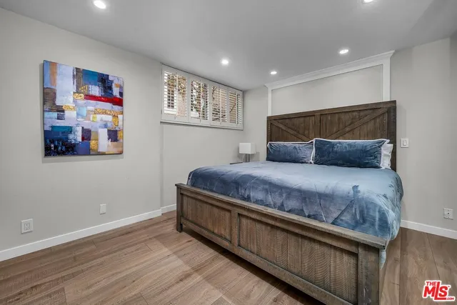 a bedroom with a bed and painting on the wall