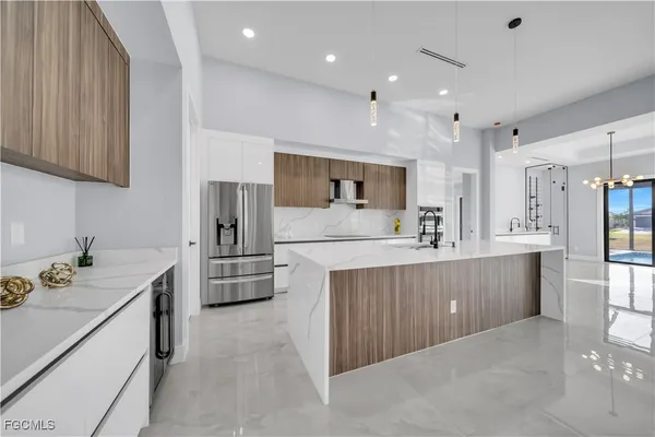 a kitchen with kitchen island sink stove and refrigerator