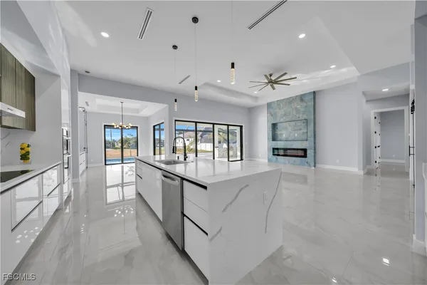 a large white room with kitchen view and a faucet