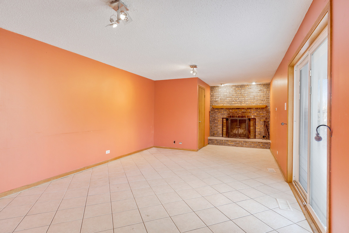 120 Ambleside Road Des Plaines, IL 60016 - Photo 11 of 22 a view of an empty room with a fireplace and a window