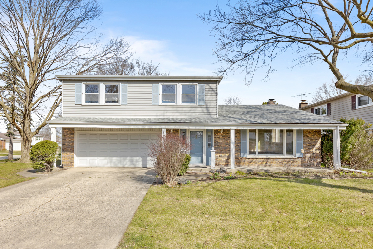 120 Ambleside Road Des Plaines, IL 60016 - Photo 2 of 22 a front view of a house with a yard and garage