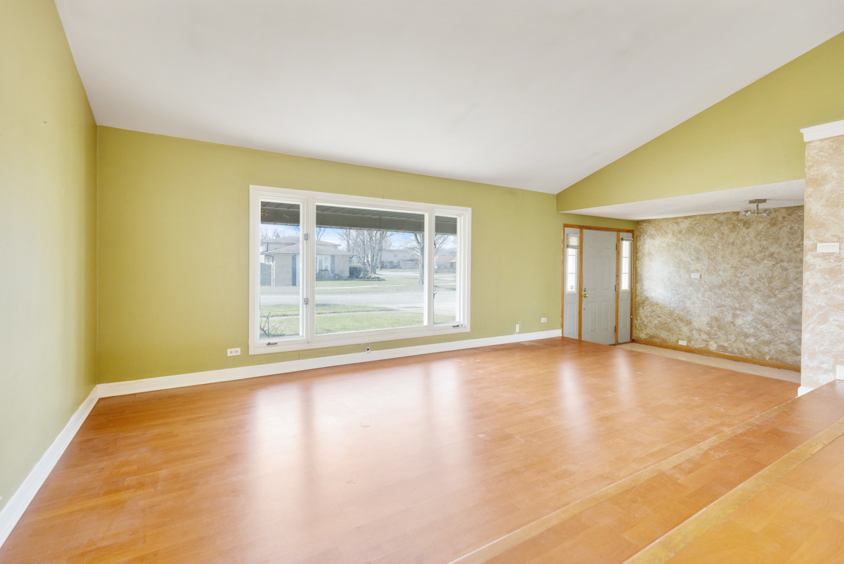 120 Ambleside Road Des Plaines, IL 60016 - Photo 5 of 22 a view of an empty room with wooden floor and a window