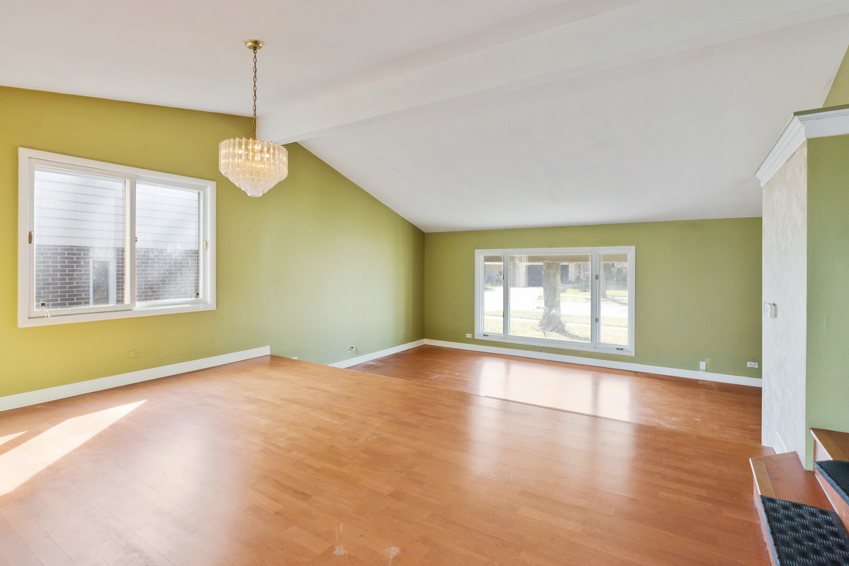 120 Ambleside Road Des Plaines, IL 60016 - Photo 6 of 22 a view of an empty room with window and wooden floor