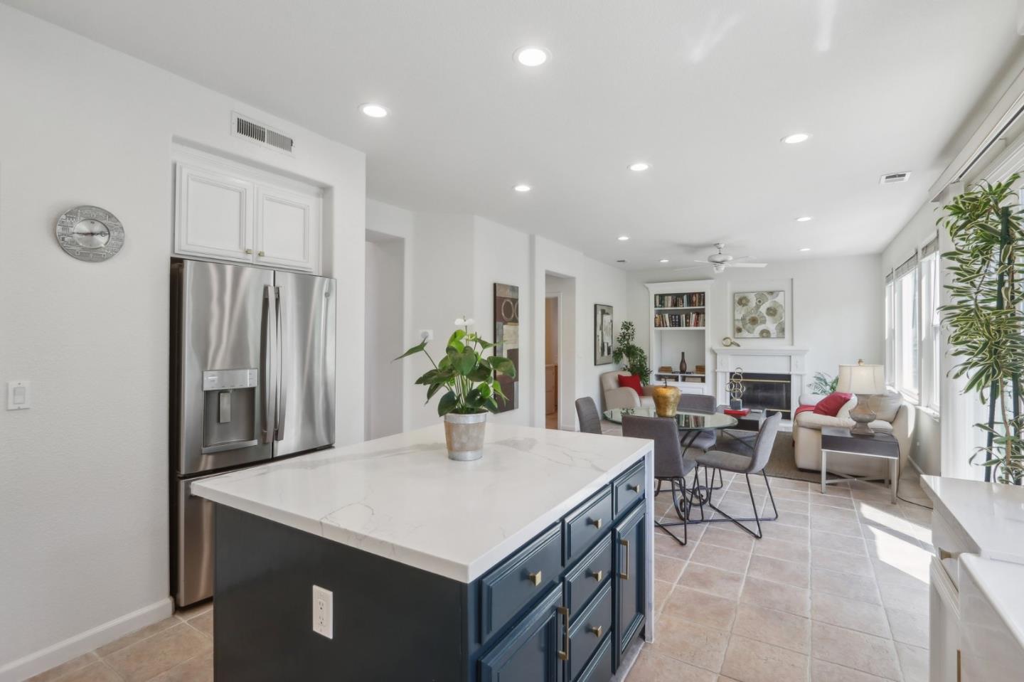 a living room with stainless steel appliances kitchen island furniture and a refrigerator
