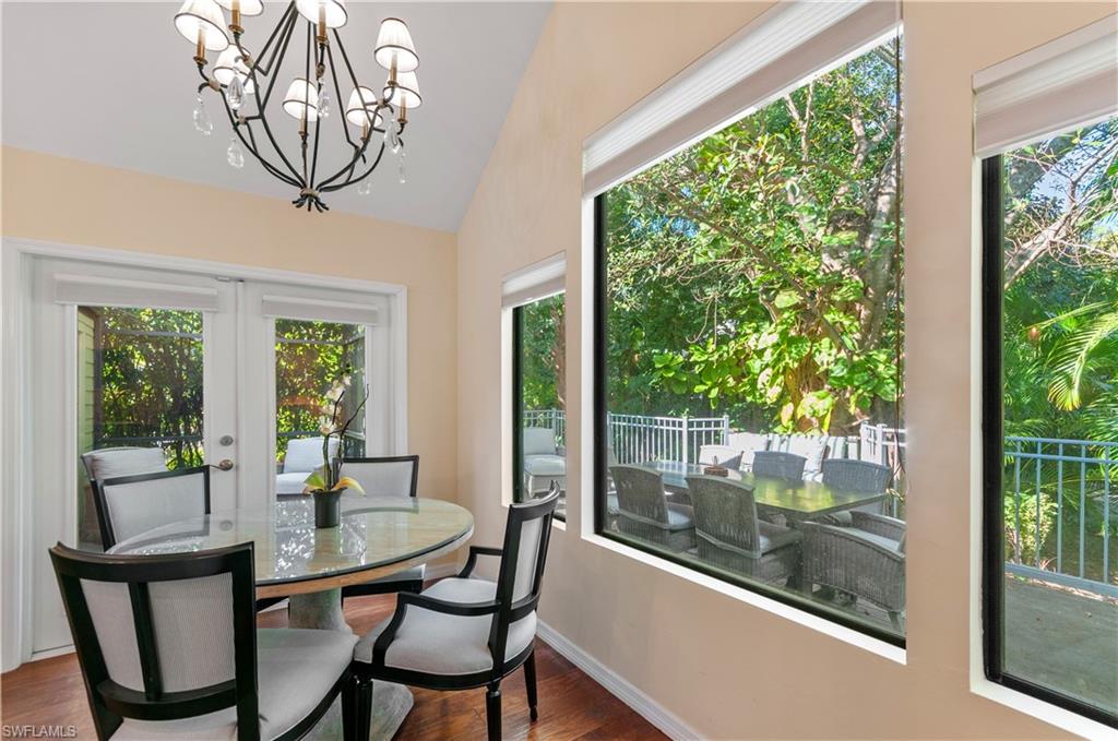 1313 Solana Road, Unit A3 Naples, FL 34103 - Photo 14 of 29 Dining area with dark wood-style flooring, a chandelier, french doors, and lofted ceiling