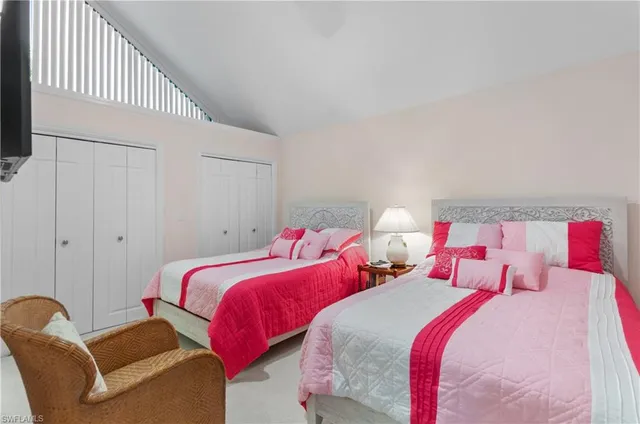 a bedroom with two beds and a lamp