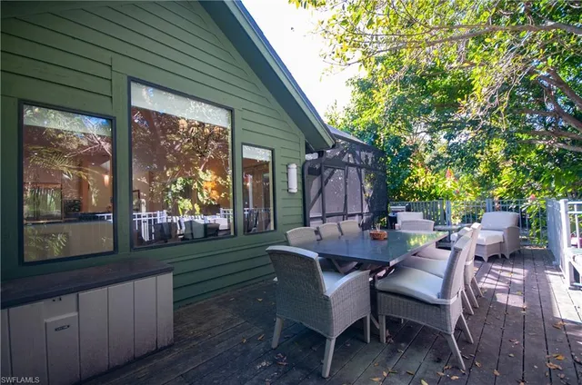 a view of a patio with table and chairs and floor to ceiling window with wooden fence