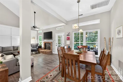 a view of a dining room and livingroom with furniture wooden floor a chandelier