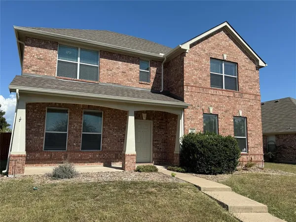 a front view of a house with yard and parking