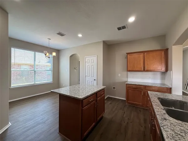a kitchen with stainless steel appliances granite countertop a sink a stove and a wooden floors