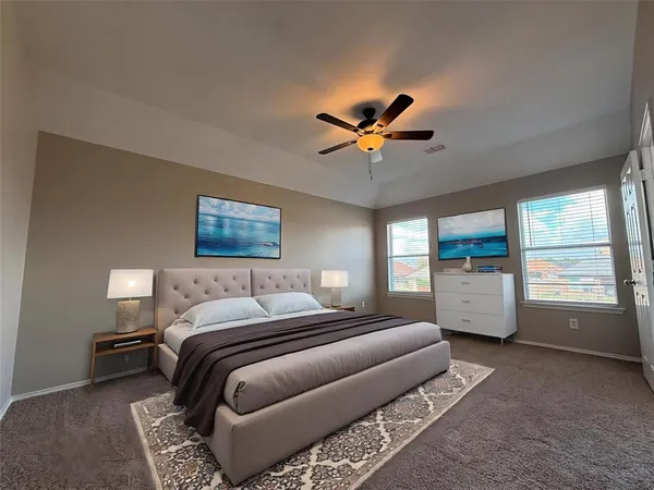 a spacious bedroom with a bed a window and a chandelier