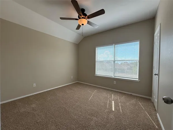 an empty room with a window and a fan