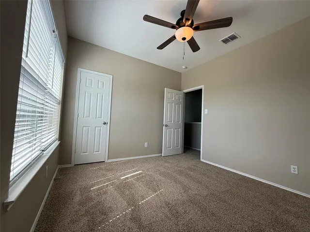 an empty room with fan and windows