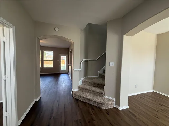 a view of a livingroom with wooden floor and stairs