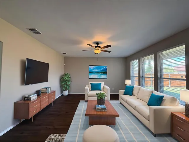 a living room with furniture a flat screen tv and a large window