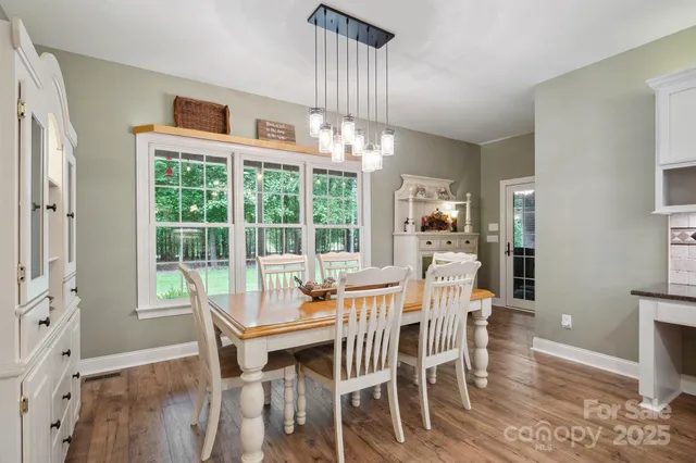 a dining room with furniture a chandelier and wooden floor