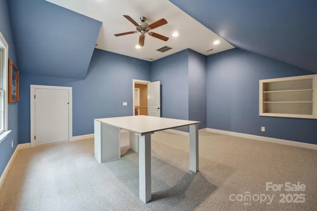 a spacious bedroom with a bed and a chandelier