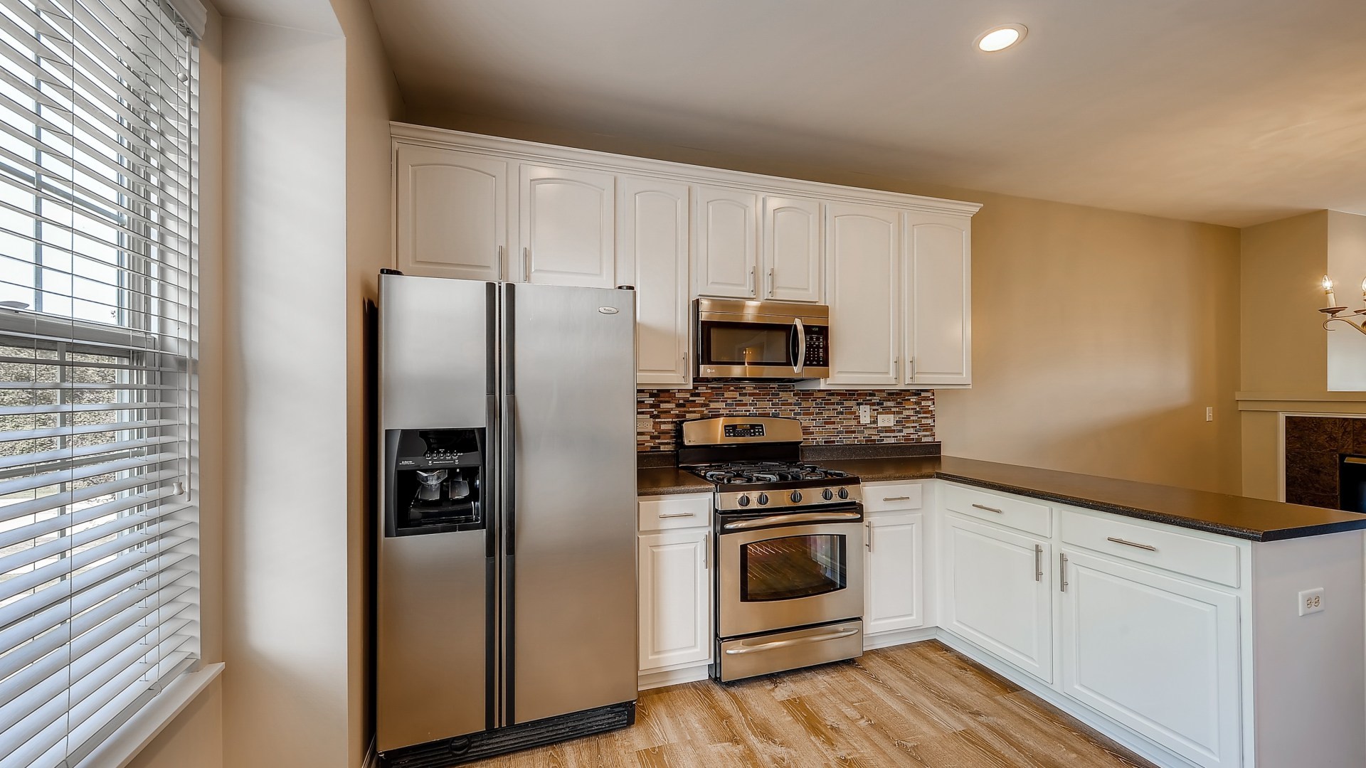 103 Willey Street Gilberts, IL 60136 - Photo 11 of 28 a kitchen with white cabinets and stainless steel appliances