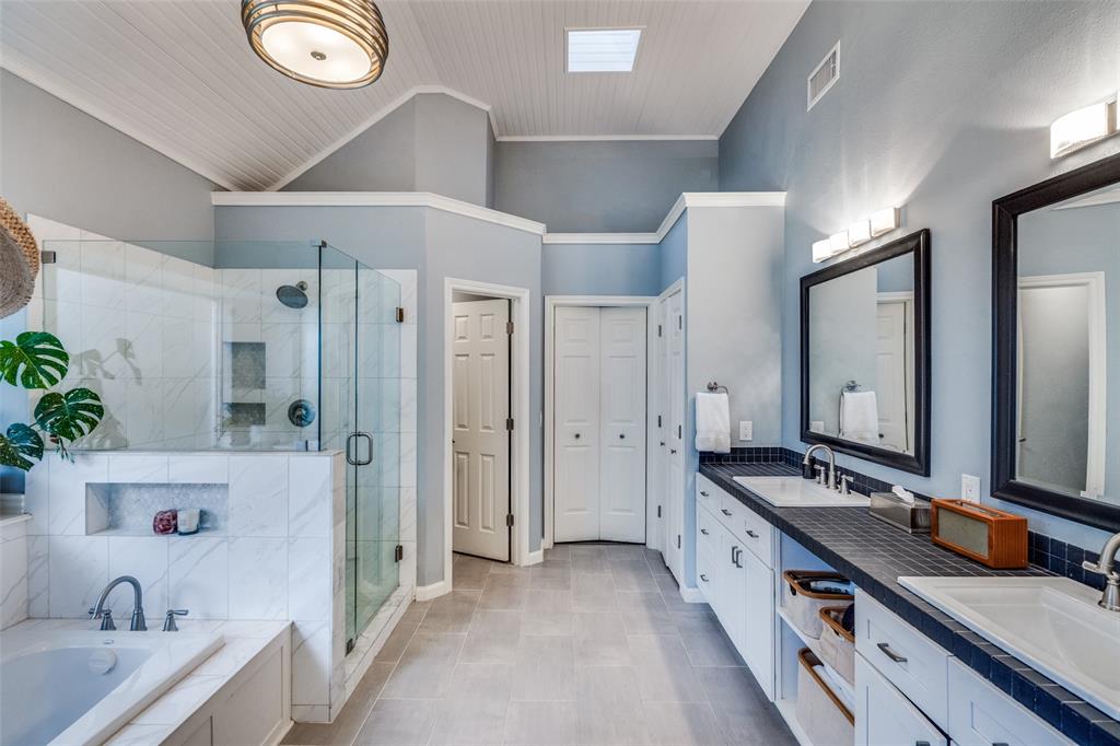 3452 Hearst Castle Way Plano, TX 75025 - Photo 29 of 36 a spacious bathroom with a double vanity sink a large mirror and a bathtub