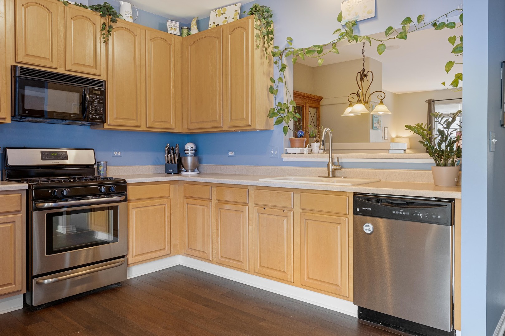 3484 Ravinia Circle Aurora, IL 60504 - Photo 6 of 26 a kitchen with stainless steel appliances granite countertop a sink a stove a microwave and wooden cabinets