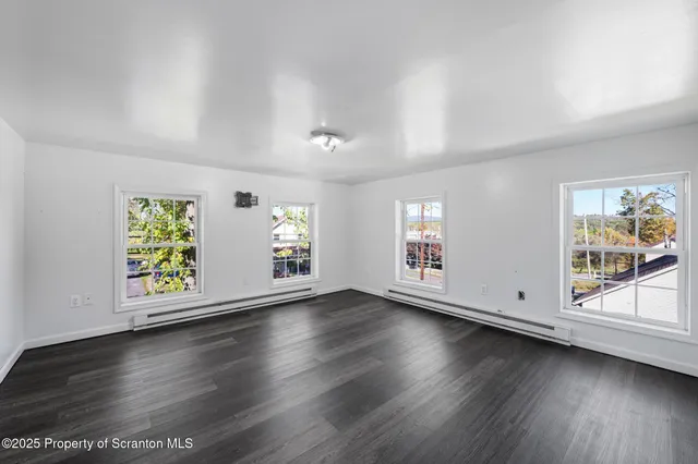 a view of an empty room with wooden floor