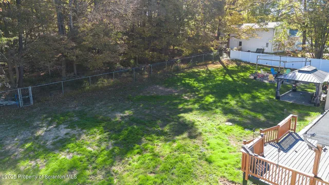an aerial view of residential house with outdoor space and trees all around