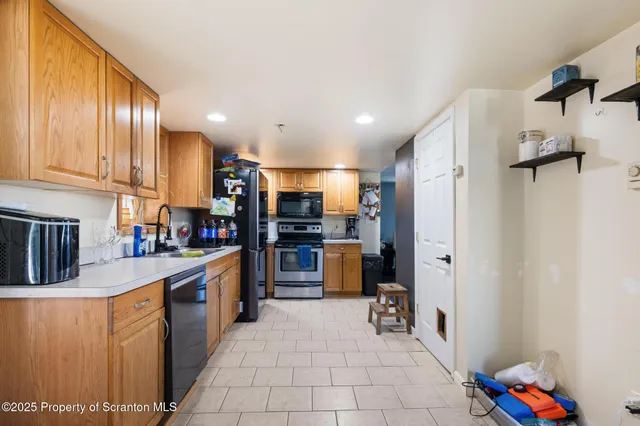 a kitchen with stainless steel appliances granite countertop a refrigerator and a stove top oven