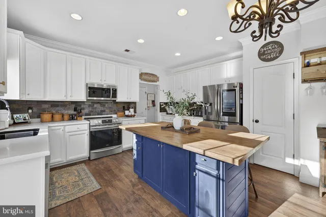 a kitchen with kitchen island granite countertop a sink cabinets and stainless steel appliances