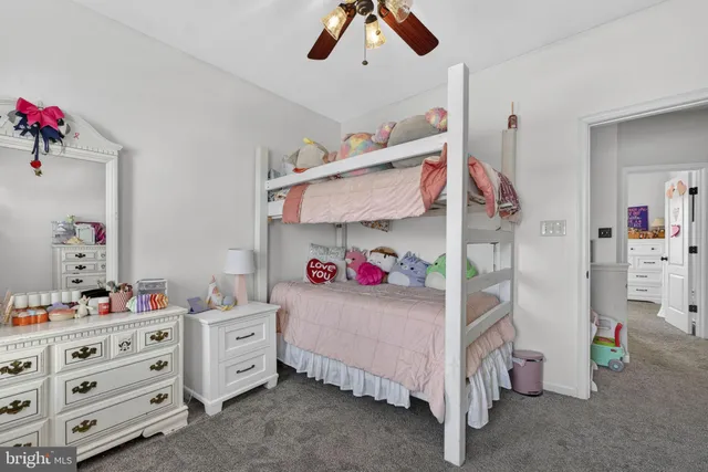 a bedroom with furniture and a chandelier fan