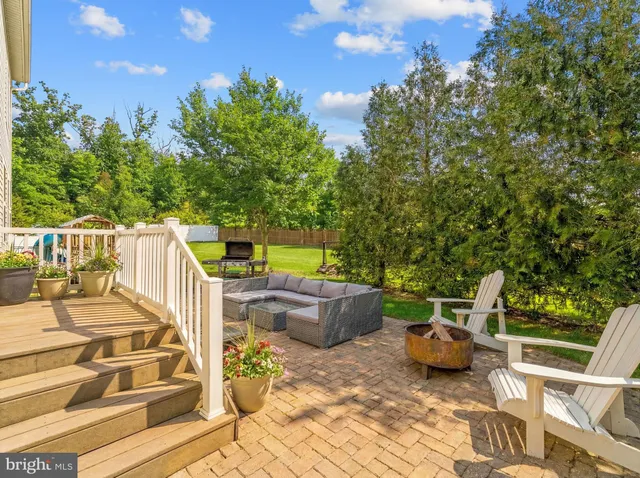 a view of a patio with table and chairs potted plants with wooden floor and fence