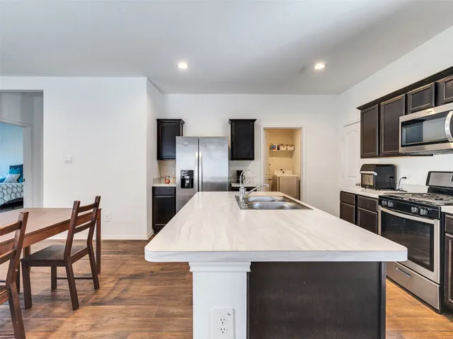 a large kitchen with kitchen island a table and chairs in it