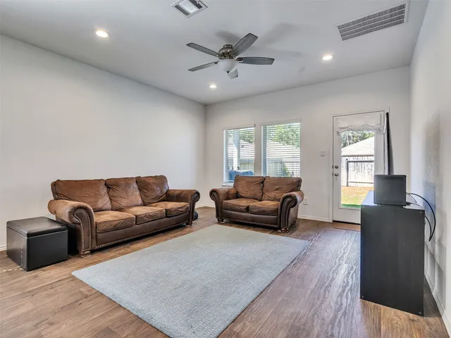 a living room with furniture and a wooden floor