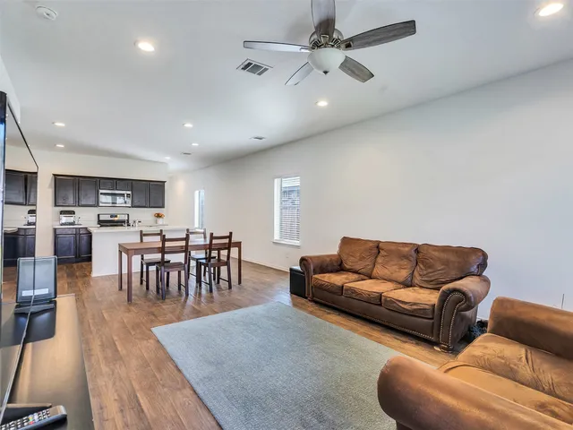 a living room with furniture kitchen view and a dining table