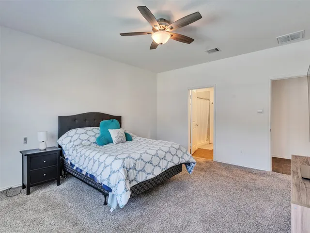 a bedroom with a bed and a ceiling fan