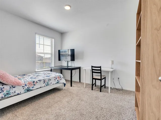 a bedroom with a bed closet and flat tv screen