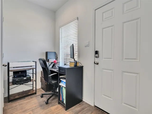 a view of a workspace with furniture and a window