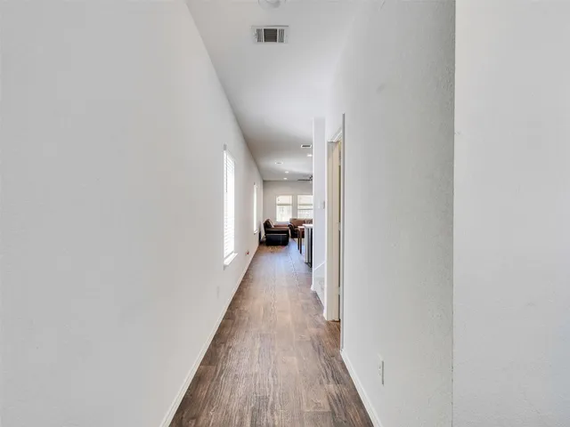 a view of a hallway with wooden floor and staircase