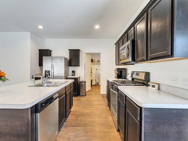 a kitchen with stainless steel appliances granite countertop a stove top oven a sink and dishwasher