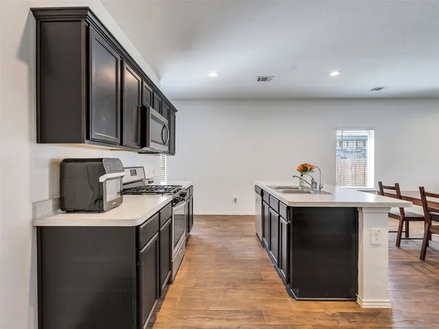 a kitchen with stainless steel appliances granite countertop a sink stove and refrigerator